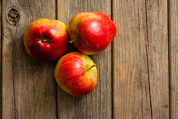 three apples on old wooden background