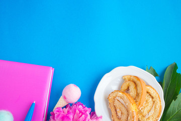 Pink notepad on a blue background. Diary with peony. Top view feminine background. The concept of holiday, women's day, mother's day, birthday. The concept of planning.