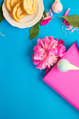 Pink notepad on a blue background. Diary with peony. Top view feminine background. The concept of holiday, women's day, mother's day, birthday. The concept of planning.