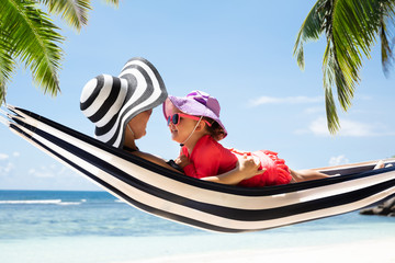 Mother And Daughter Lying On Hammock