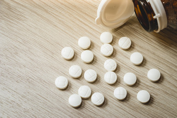 Fototapeta na wymiar Pills Bottle with Vitamins inside on wood background , zinc , vitamins a, multivitamins.