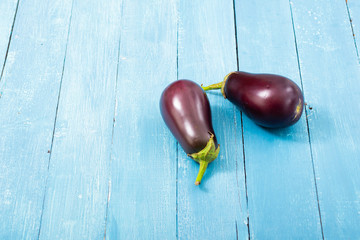 two eggplants on blue wood table