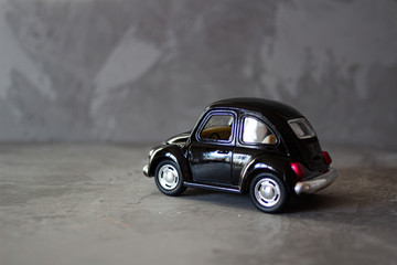 Obraz na płótnie Canvas Old vintage mini black toy buggy car. Toy transportation concept in macro. Close-up food logistics visualisation.