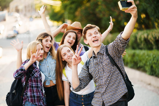 Friendship, togetherness, youth, holidays. Group of friends taking selfie at camera in city