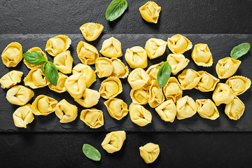 Ravioli with spinach and ricotta on black background, top view