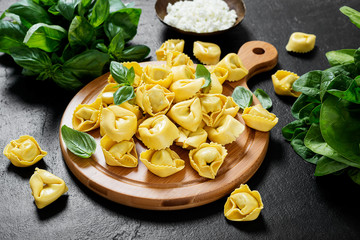 Ravioli with spinach and ricotta on black background, top view