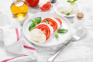 Caprese salad with fresh tomatoes, mozzarella cheese and basil.