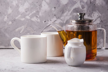 Black or masala tea in a teapot on a gray minimalistic background