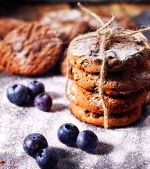 Bakers gonna bake. Serving food on slate. Oatmeal cookies biscuit with blueberry on dark tiles countrylike. Chocolate chip cookies tied with string shop on window display. High carbohydrate content.