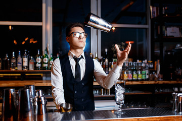 barman at work. A young bartender works with a shaker. Prepares delicious alcoholic cocktails