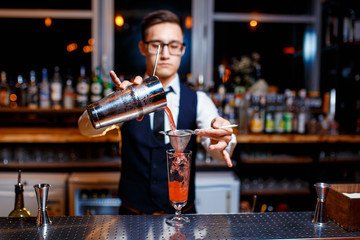 The bartender prepares a delicious orange cocktail with citrus. bartender at work