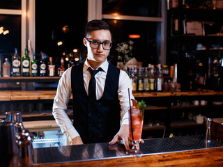 The bartender prepares a delicious orange cocktail with citrus. bartender at work