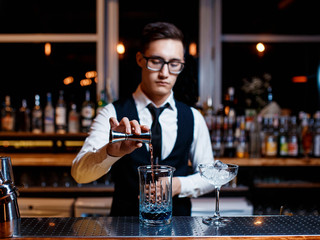 The bartender prepares a cool blue lagoon cocktail. Barman at work