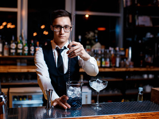 The bartender prepares a cool blue lagoon cocktail. Barman at work