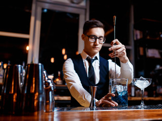 The bartender prepares a cool blue lagoon cocktail. Barman at work