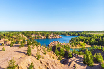 Fototapeta na wymiar Aerial view of picturesque hills and blue lakes in Konduki, Tula region, Russia. Turquoise quarry in Romantsevo.