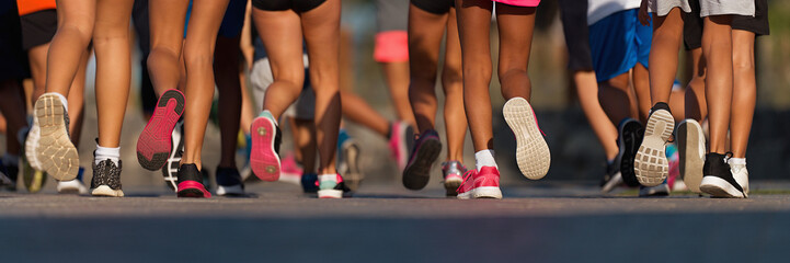 Running children, young athletes run in a kids run race,running on city road detail on legs,running...