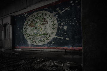 painted flag of belize on the dirty old wall in an abandoned ruined house.