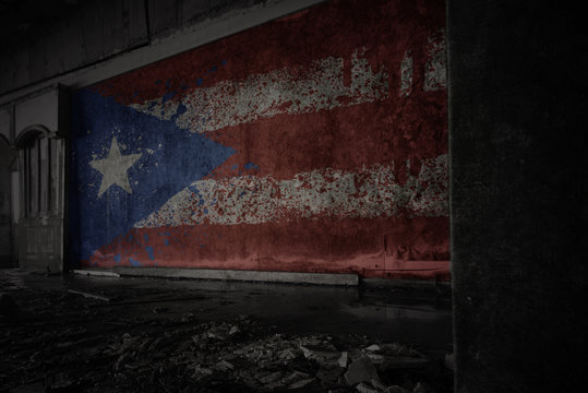 painted flag of puerto rico on the dirty old wall in an abandoned ruined house.