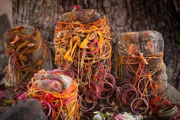 Tuinposter colorful red and orange offerings at aholy tree near a temple in the south of india © peter verreussel