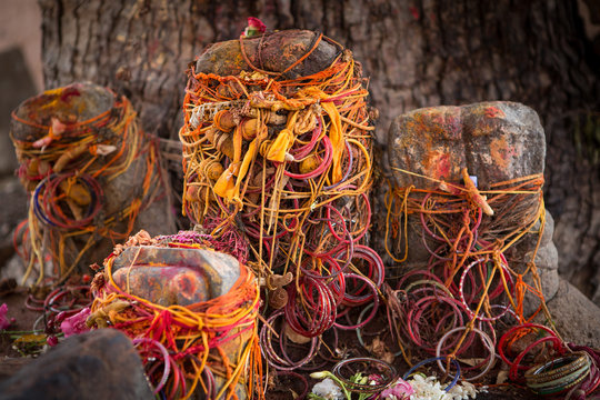 colorful red and orange offerings at aholy tree near a temple in the south of india