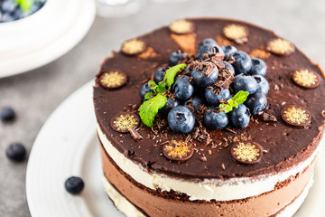 Belgian Chocolate Layered Gateau. Layers of moist choco sponge, vanilla cream and indulgent dark chocolate mousse glazed with rich dark chocolate sauce and hand decorated with fresh blueberries