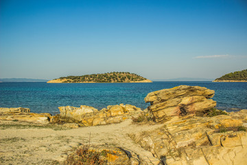 Greece beach waterfront scenic landscape on Mediterranean island shoreline with view on sea and horizon line, beautiful summer vacation destination 