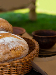 round bread hot delicious piece of whole bun in a macro basket on a blurry background of ceramic dishes bowls