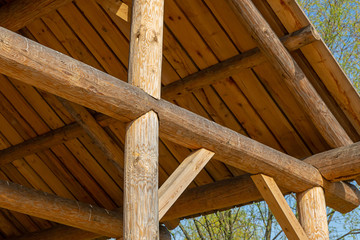 sloping roof rustic building round beam on a blue sky background natural material