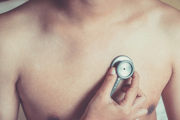 Doctor examining patient with stethoscope in hospital. Medical examination, stethoscope, medicine and therapy.