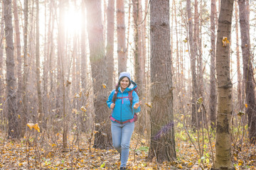 People, hike and nature concept - Woman dressed in blue jacket walking in the forest