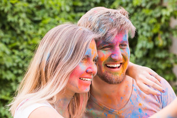 Festival holi, people concept - young couple taking selfie in colourful dirty clothes