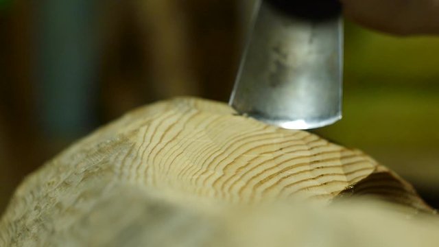 the sculptor carves a figure from a tree