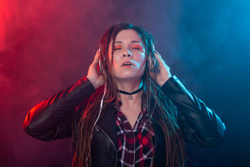 Meloman, music and people concept - young woman with dreadlocks listen to the music and enjoy it