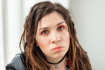 Fashion and beauty concept - young stylish woman in dreadlocks and colourful makeup