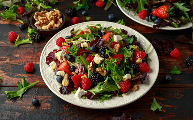 Fresh Fruit Salad with blueberry, strawberry raspberry, walnuts, feta cheese and green vegetables. healthy summer food
