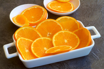 Slices of orange on white dishes.