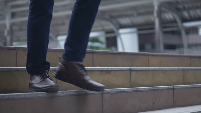 Close up of the legs asian businessman walking in the street.
