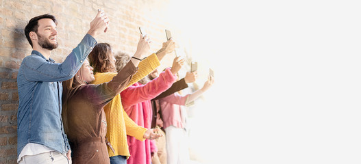 Group of young people making selfies, each with its respective smartphone. Subject isolated for...