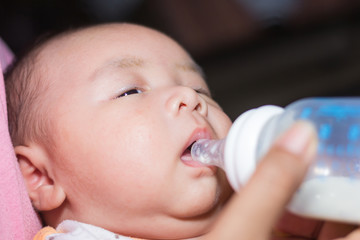 Mother feeding the baby Children eat milk from bottles