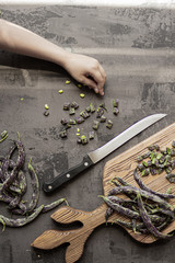 Green and black fresh organic sliced beans on isolated background with blue and white cloth and...