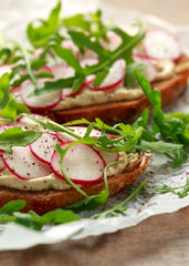 Hummus sourdough toast with reddish and wild rocket. Healthy vegan food