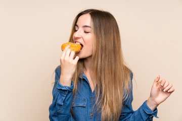 Young woman holding a donut over isolated background