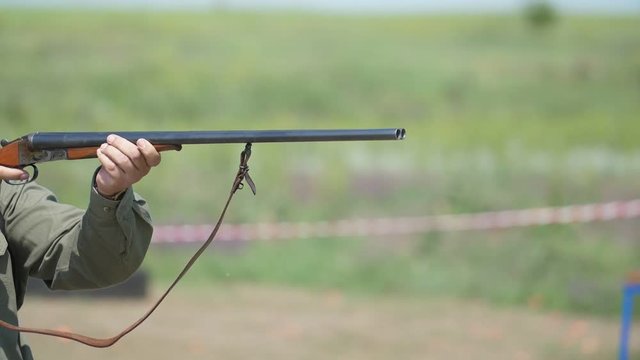 Rifle firing at clay pigeons at a skeet shooting range in summer in slow motion 
