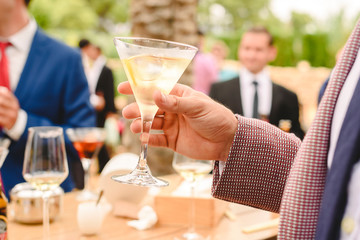 People in a cocktail drinking alcohol from their glasses and having fun at the party.