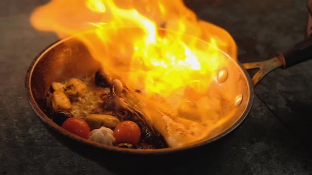 Seafood meal cooking. Mediterranian food recipe. Chef flambering skills.