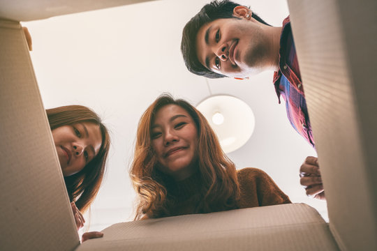 Group of young people opening and looking for a gift in the box