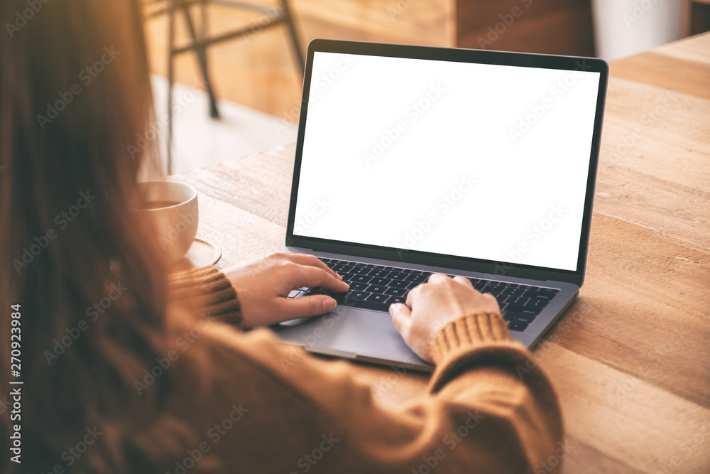 Wall mural mockup image of a woman using and typing on laptop computer keyboard with blank white desktop screen