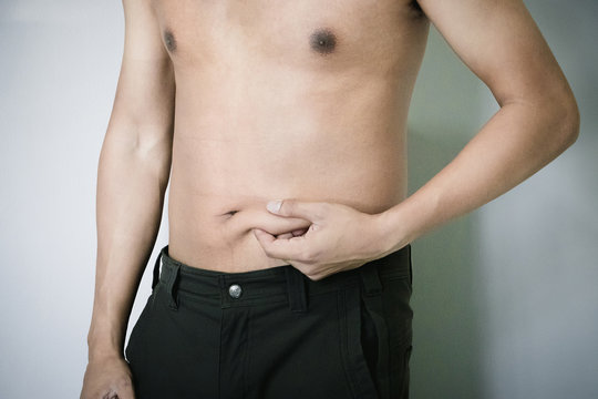 Fat young man measuring isolated over white background.