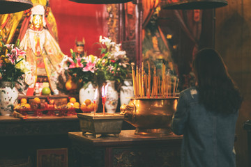 A woman paying respect to buddha image in Chinese temple